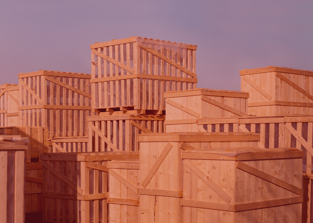 wooden industrial crating and packing crates stacked in a pink hue